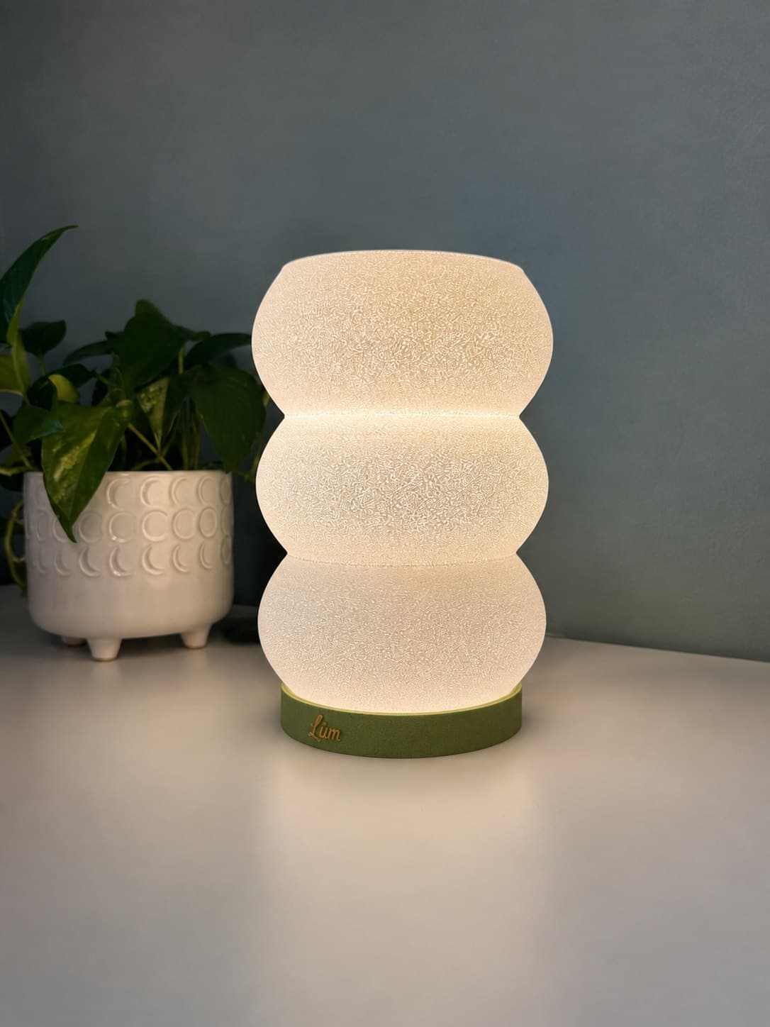 Matcha green Wave Still glowing on a desk with a plant
